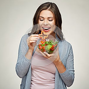 Young smiling woman eating salad. photo