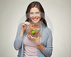 Young smiling woman eating salad. photo