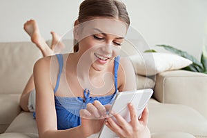 Young woman enjoying using mobile applications on tablet at home