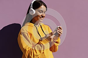 young smiling woman with headphones chating phone