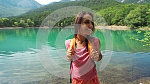 Young smiling Woman hiker looking at scenery landscape with beautiful mountain lake