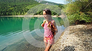 Young smiling Woman hiker looking at scenery landscape with beautiful mountain lake
