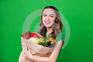 Young smiling woman holding a bag full of healthy