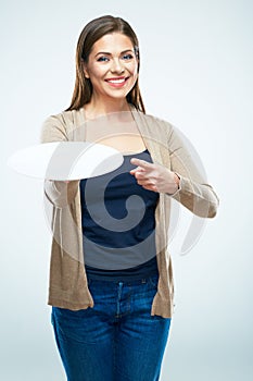 Young smiling woman holding empty plate and finger pointing.