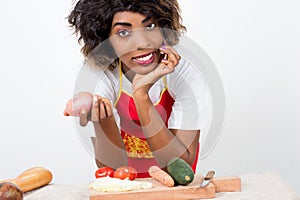 Young smiling woman holding fresh vegetables in her kitchen