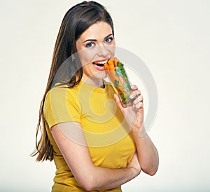 Young smiling woman holding glass with carrot.