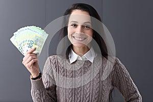 Young smiling woman holding lot of euro bills in her hands