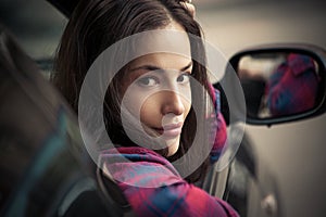 Young smiling woman look out from car window