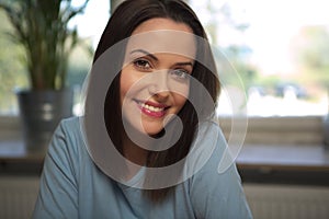 Young smiling woman looking straight ahead