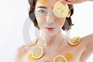 Young smiling woman with many lemon pieces