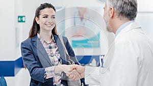 Woman meeting the doctor and shaking hands photo