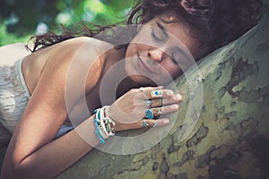 Young smiling woman nature lover enjoy in summer day hug a tree
