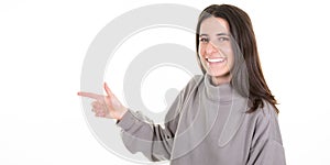 Young smiling woman pointing side at copyspace looks in camera in banner web header