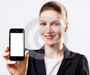 Young smiling woman presenting smartphone with blank screen.