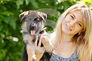 Young smiling woman with puppy of german shepherd