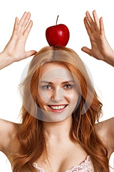 Young smiling woman with red apple on head