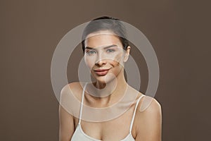 Young smiling woman with repairing cream on clear healthy skin