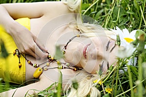 Young smiling woman resting in grass.