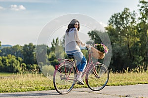 Young smiling woman rides a bicycle