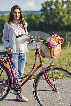 Young smiling woman rides a bicycle in countryside