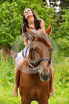 Young smiling woman riding horse