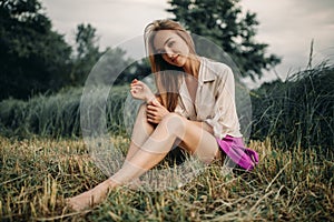 Young smiling woman sits on bevelled meadow. photo