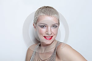 Young smiling woman with short blonde hair and fancy makeup
