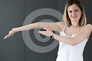 Young smiling woman showing her bent arm