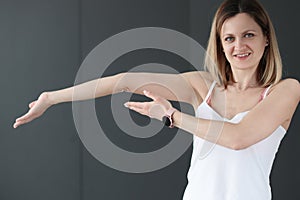Young smiling woman showing her bent arm photo