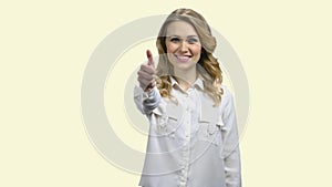 Young smiling woman showing thumb up sign.