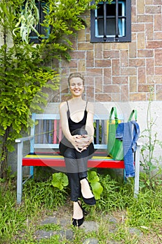 Young smiling woman sitting on the benc