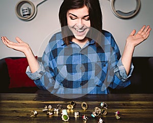 Young smiling woman sitting in front of rings on a table