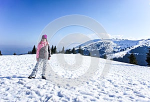 Smiling girl on the Kopaonik ski slope in ski clothes. Beautiful mountain view, winter landscape