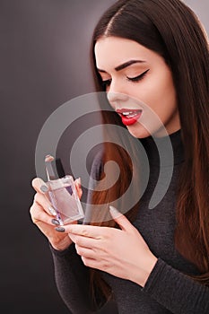 Young smiling woman spraing parfumes in the bathroom