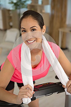 young smiling woman with towel after training on treadmill