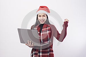 Young smiling woman wearing red Santa Claus hat making video call on social network with family and friends on white background