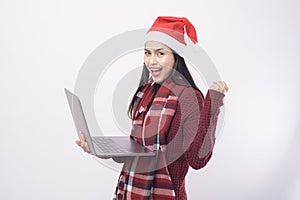 Young smiling woman wearing red Santa Claus hat making video call on social network with family and friends on white background