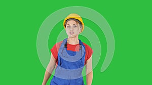 Young smiling worker woman talking and showing objects to her sides on a Green Screen, Chroma Key.