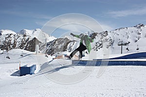 Young snowboarder man sliding on a box.