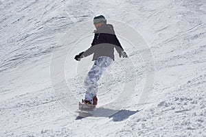 Young snowboarder woman sliding downhill.