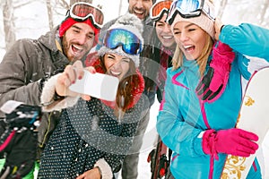 Young snowboarders or skiers making selfie in fog forest