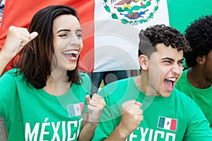 Young soccer fans from Mexico with mexican flag