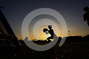 Young Soccer Goalie in Action During Evening Training Session. Boy Soccer Player Catch Ball at Practice Drill.