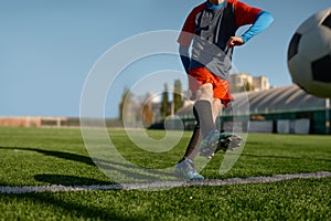 Young soccer goalie starting game kicking ball from white goal line