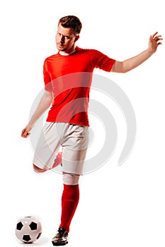 Young soccer player with ball on black background in studio.