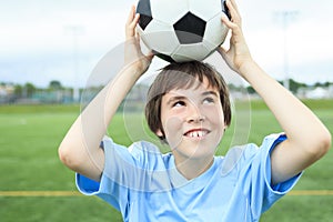 Young soccer player with ball on the field