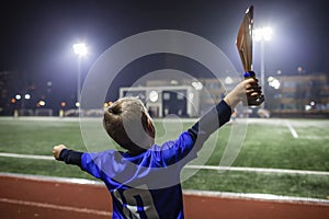 Young soccer player in blue jersey with ten number holding a winners cup after the winning goal