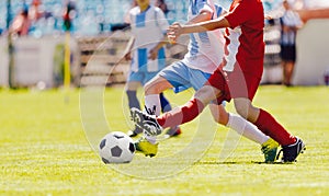 Young soccer players compete in a game. Two boys kicking football ball on tournament match