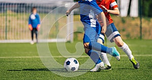 Young soccer players compete in tournament game. Children running after football ball