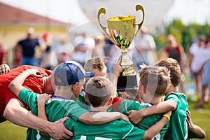 Young Soccer Players Holding Trophy. Boys Celebrating Soccer Football Championship